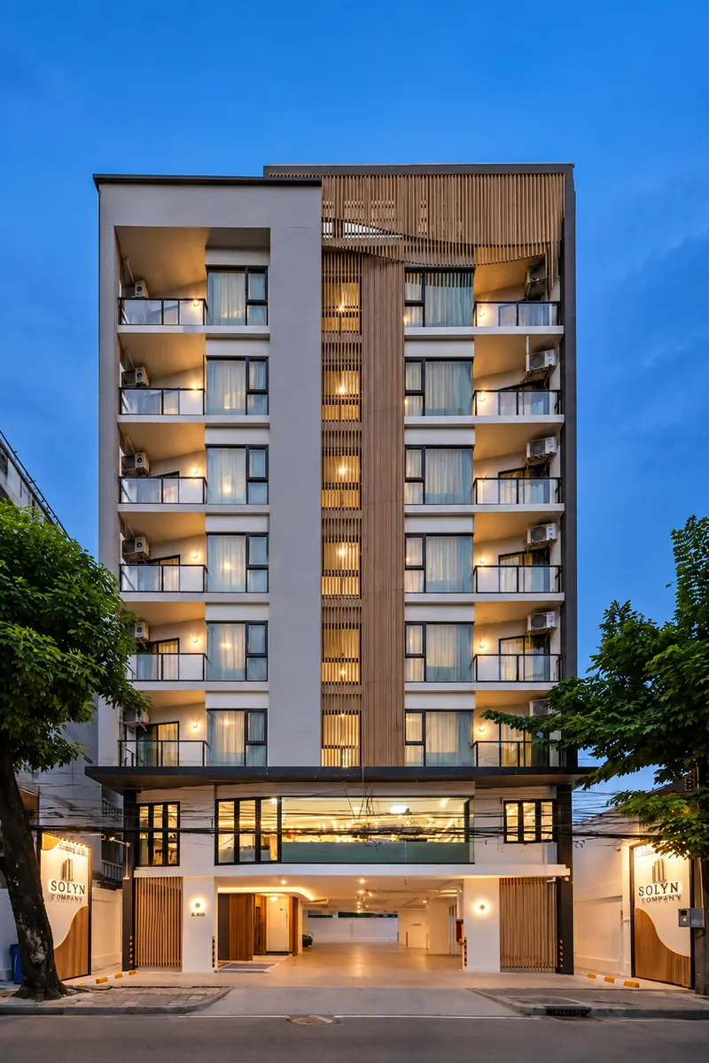 อาคาร Solyn Hotel ยามพลบค่ำ มองจากถนนเห็นทางเข้าที่เปิดไฟสว่าง